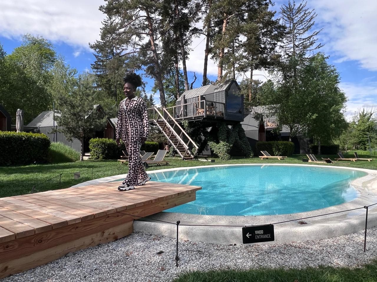 Yina Riascos at the Tante Frida glamping village in Slovenia — pool deck with treehouse cabins
